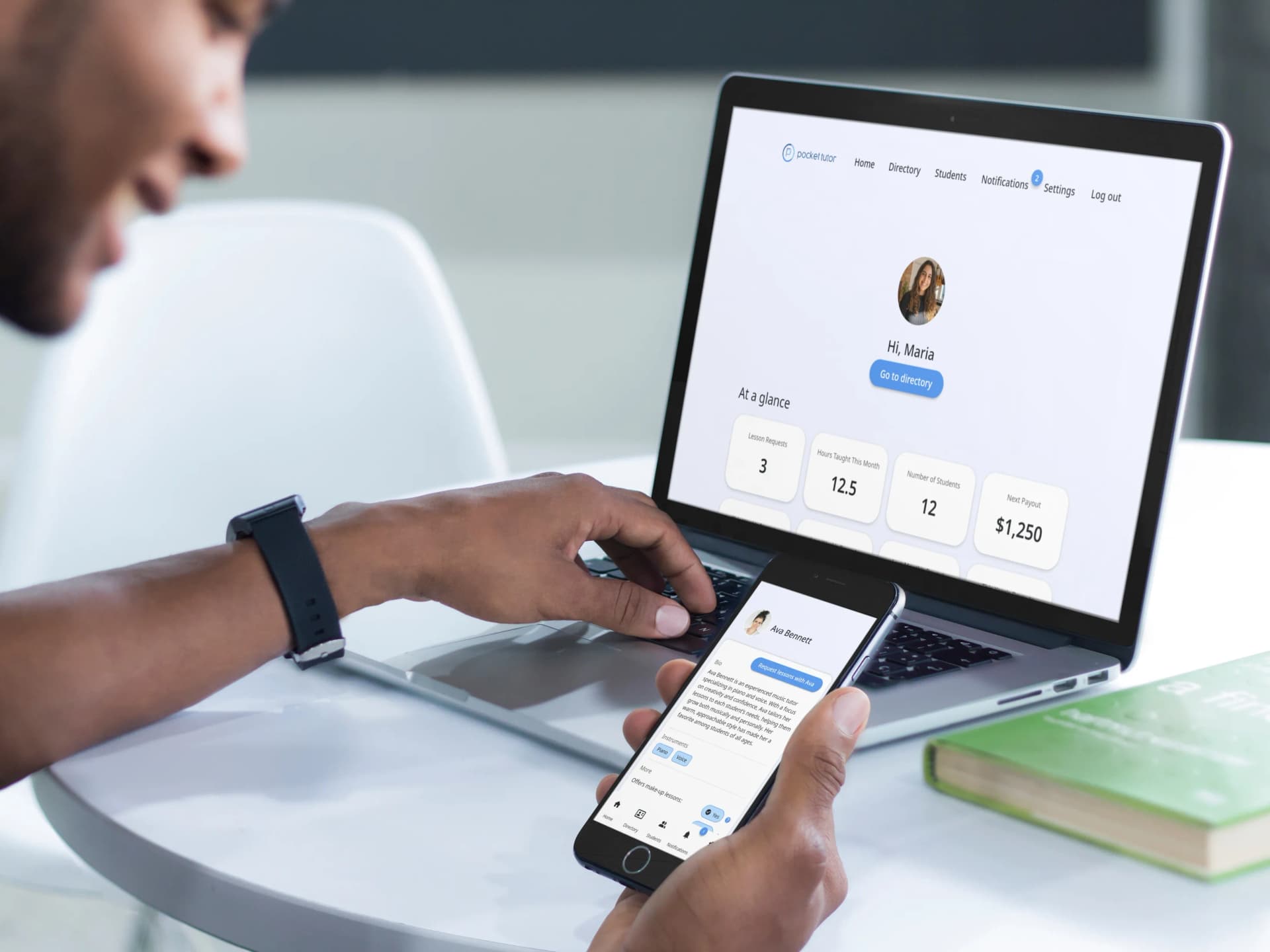 A man using a MacBook with Pocket Tutor on screen while holding an iPhone.